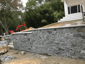 Dry-Laid Stone Wall Installation in a residential landscape featuring natural stone and precision craftsmanship.