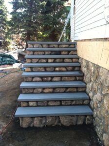 Back entrance staircase made of natural stone and concrete steps